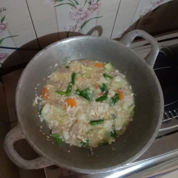 masukkan nasi masak hingga mendidih lalu koreksi rasa. masukkan cabai utuh sebelum matikan api