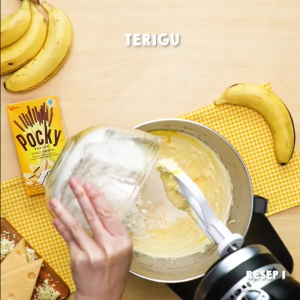 Masukkan Pocky Banana dan 150 gr keju, lalu aduk merata.