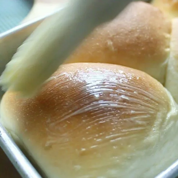 angkat roti dari oven, olesi roti dengan mentega