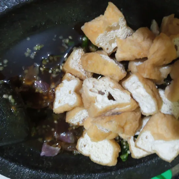 Tambahkan air rebusan dan tahu pada ulegan cabai dan bawang merah. Aduk rata, siap disajikan.