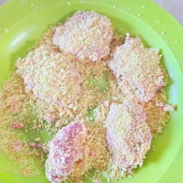 Ambil adonan nugget. Letakkan potongan keju di tengah adonan. Tutupi keju dengan sedikit adonan nugget. Baluri dengan tepung terigu basah dan tepung roti.