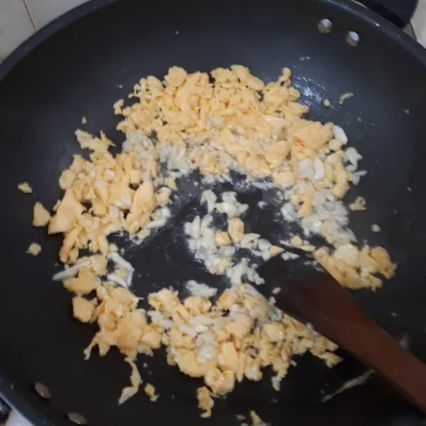 Panaskan wajan, taruh minyak sayur, goreng telur terlebih dahulu setengah bagian. Setelah telur hampir matang, masukkan bawang putih.