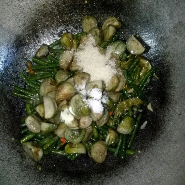 Tambahkan terong, gula, garam, penyedap rasa. Aduk dan tumis sebentar.