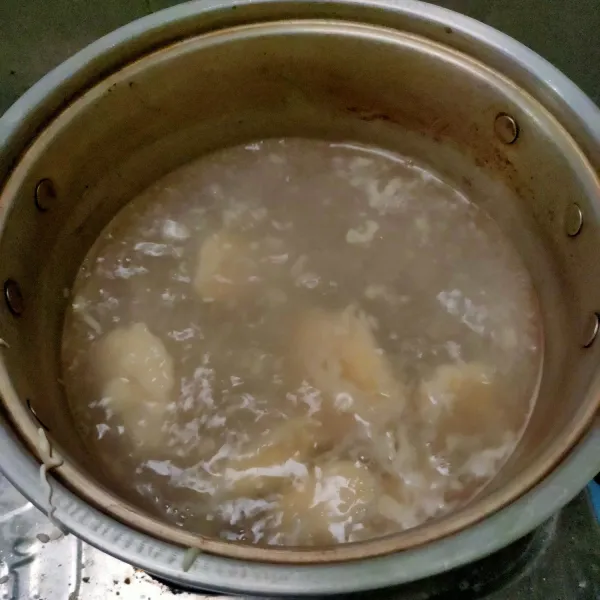 Lumuri pisang dengan tepung, masukkan ke air yang mendidih di atas kompor. Tunggu pisang naik ke permukaan. Diamkan 2 menit agar tepung matang sempurna.