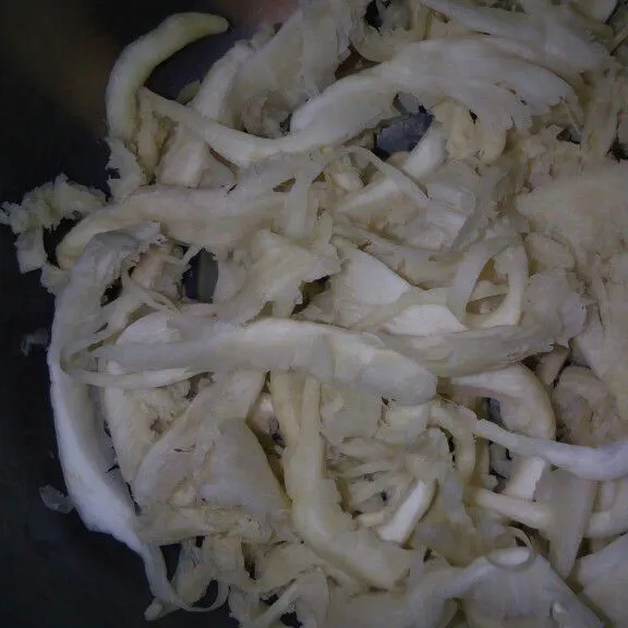Suwir jamur putih menjadi tipis-tipis kemudian cuci bersih dan peras jamur