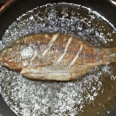 Goreng ikan nila setengah matang di minyak panas. Tiriskan.