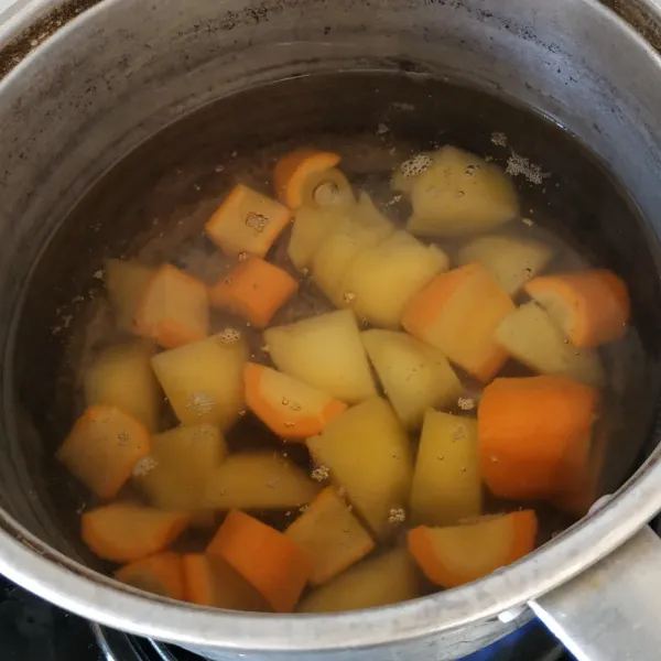 Rebus kentang dan wortel yang sudah dipotong-potong. Rebus sekitar 10 menit hingga empuk. Lalu angkat dan tiriskan