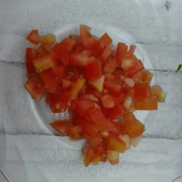 potong 1 buah tomat merah seperti dadu