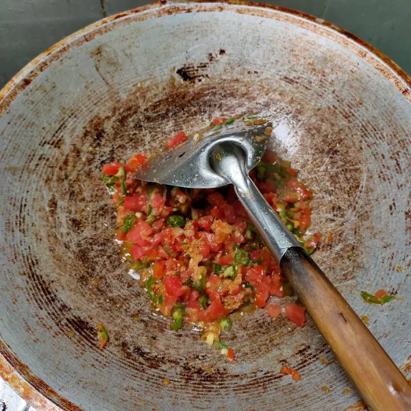 Tumis bumbu halus dan jahe geprek sampai harum. Masukkan irisan cabai hijau dan tomat. Aduk-aduk sampai tomat layu.