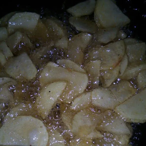 Goreng sampai matang potongan kentang yang sudah diiris tipis