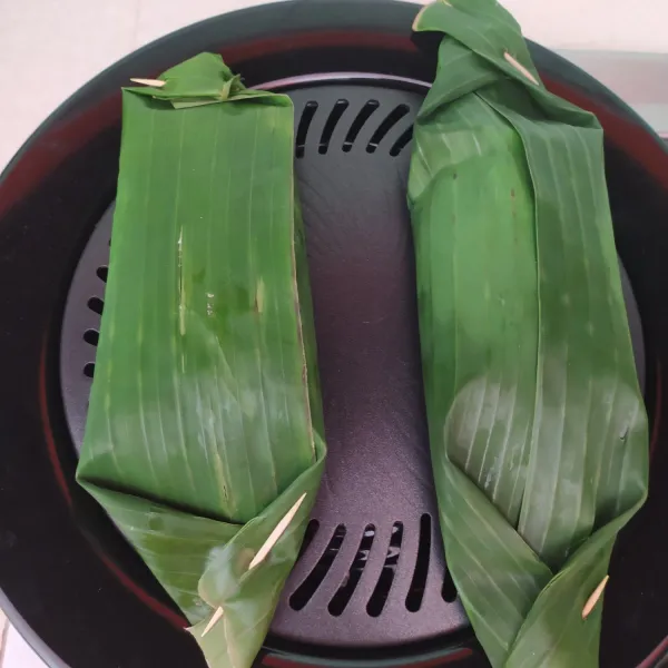Bakar nasi sampai daunnya kecoklatan. Angkat dan siap disajikan.