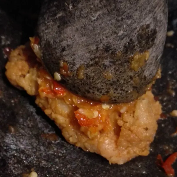 Letakkan ayam pada cobek berisi sambal. Geprek/uleg sebentar ayam gorengnya.