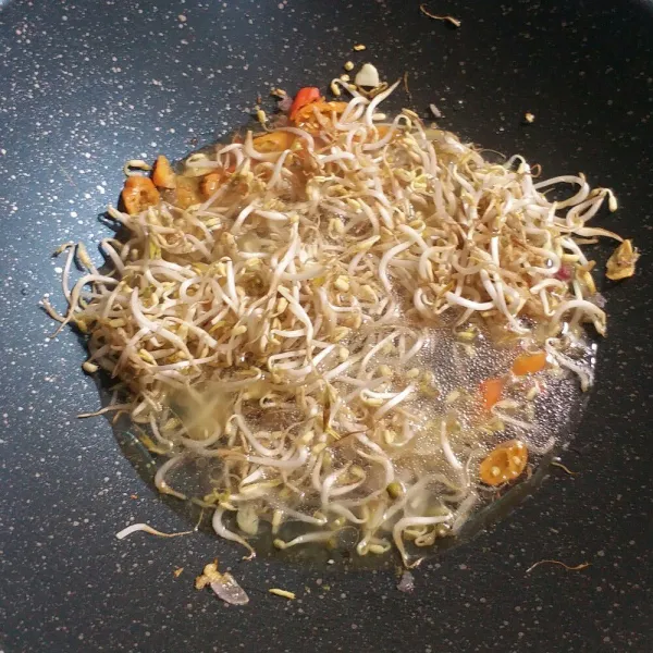 Masukkan tauge aduk rata, lalu tambahkan sedikit air.