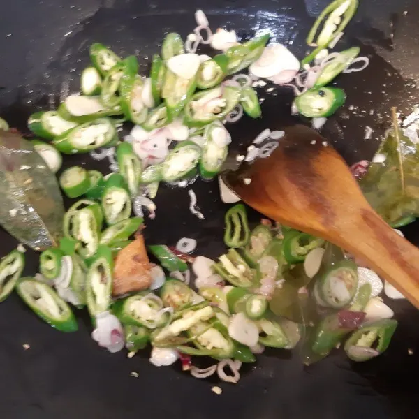 Masukkan cabai hijau besar, cabai rawit hijau, daun salam, dan lengkuas tumis sampai agak layu.