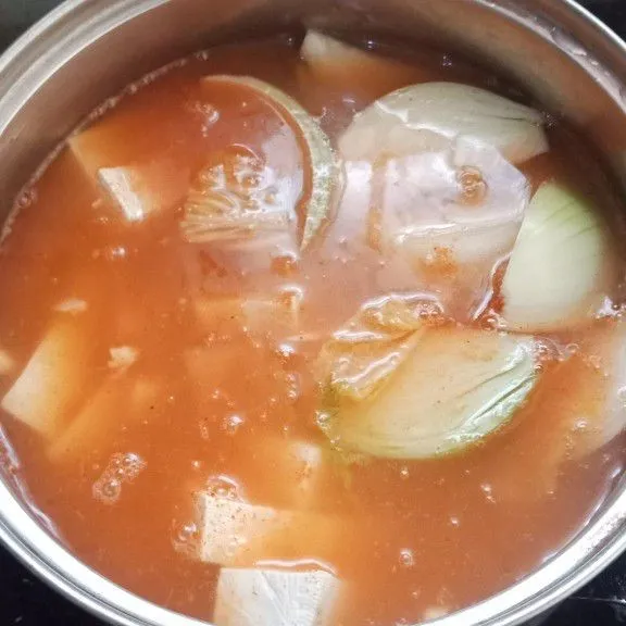 Tambahkan air kimchi dan air biasa masak hingga kuah menyusut.