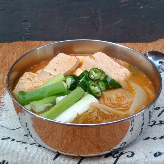 Sajikan Kimchi JJjigae dengan irisan cabai hijau besar.