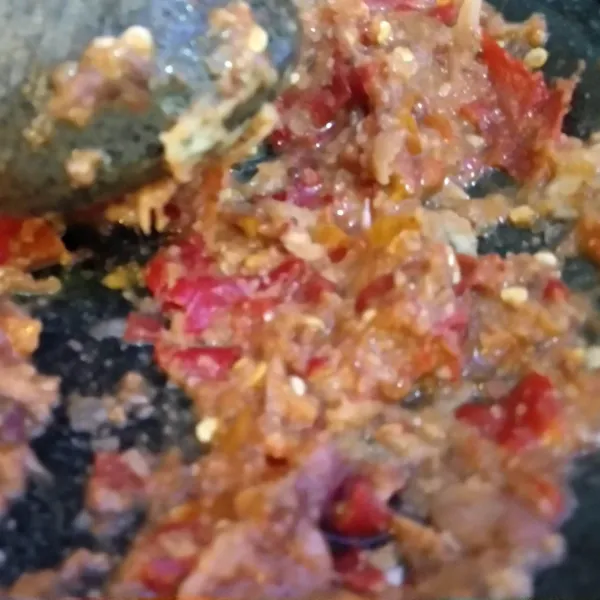 Haluskan bawang putih, bawang merah, kemiri sangrai, terasi bakar, dan tomat.