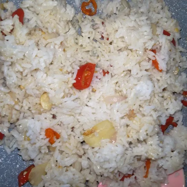 Campur rata nasi dan bumbu.