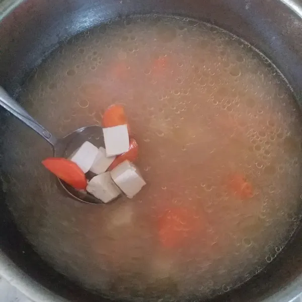 Masukkan tahu dan wortel, aduk rata.