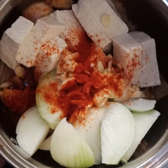 Siapkan panci masukan kimchi irisan bawang bombay tahu cabe bubuk dan bawang putih.