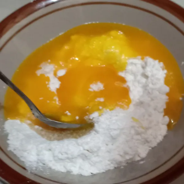 Masukkan adonan kuning telur ke dalam tepung terigu lalu aduk hingga rata.