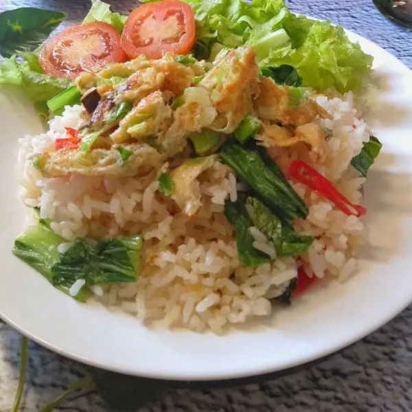 Potong telur sesuai selera, letakkan diatas nasi goreng. Nasi siap disajikan.