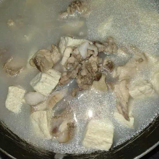 Rebus ayam dan tahu sampai ayam berubah warna putih. Lalu taruh di dalam wadah.