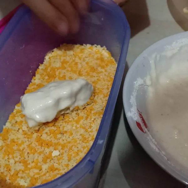 Angkat nugget dan baluri dengan tepung roti.