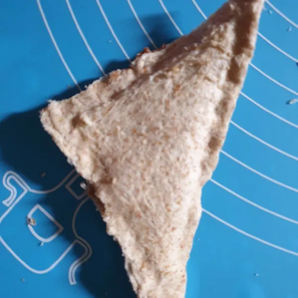 Tumpuk dengan belahan roti lain. Lalu pipihkan pinggiran roti.