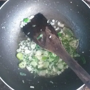 Masak nasi goreng. Masukan minyak goreng secukupnya, 1 siung bawang putih yang sudah dicincang, sisa bawang prei. Masak hingga wangi dan kecokelatan.