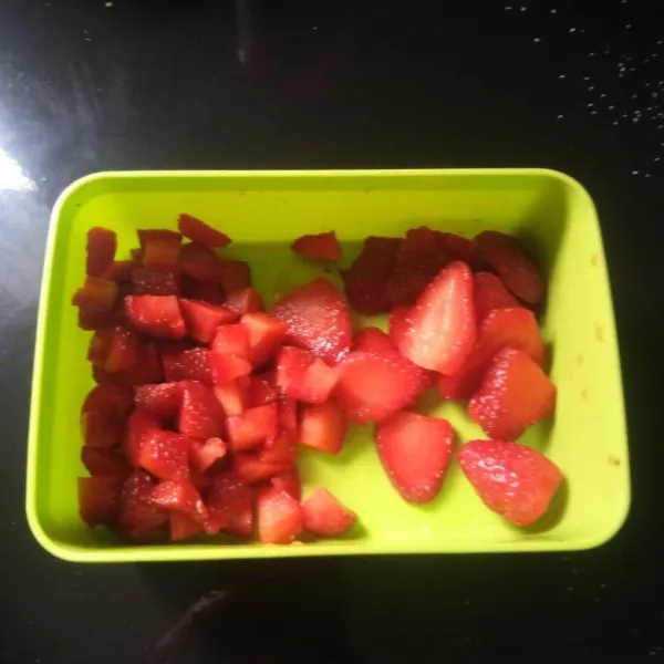 Cuci bersih dan potong strawberry menjadi dua bagian.