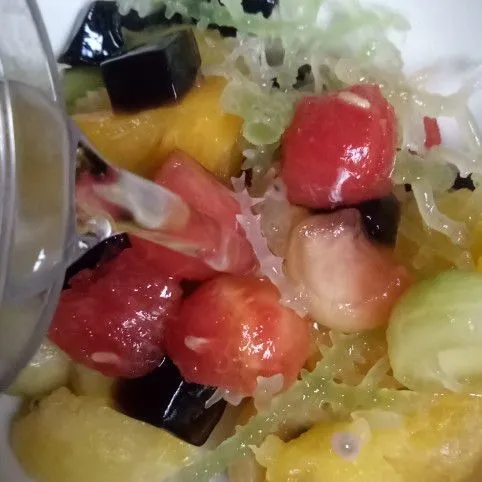 Masukkan buah semangka, melon, cincau, rumput laut dan nanas dalam wadah. Tuangi air es.