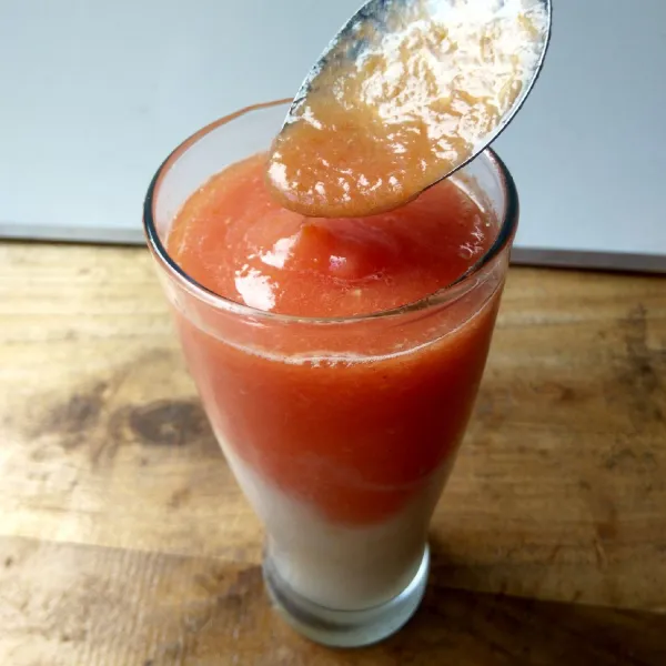 Tuang jus tomat di atas jus pir secara perlahan menggunakan sendok agar jus tidak tercampur. Sajikan.