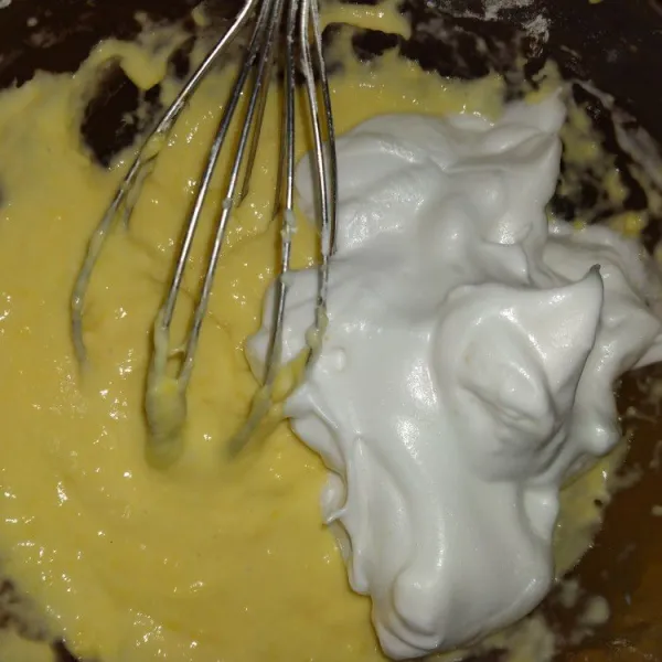 Masukkan setengah adonan putih telur ke adonan kuning telur, lalu aduk hingga merata.