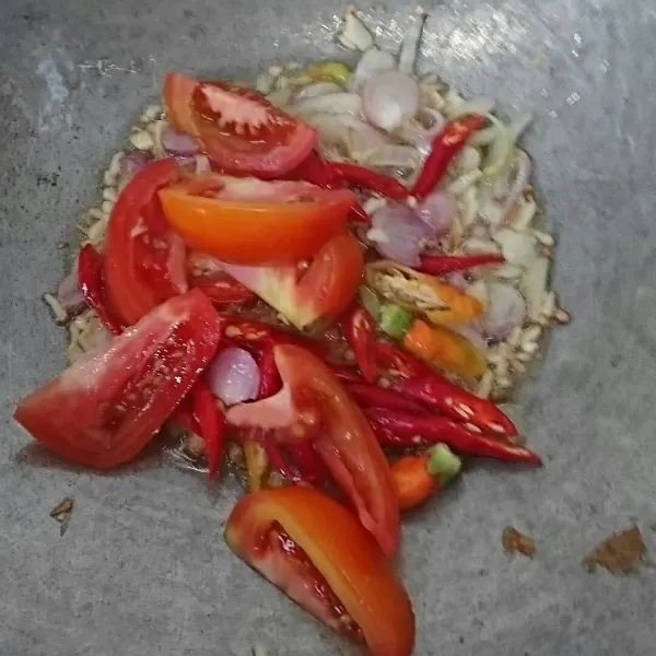 Tambahkan cabai dan tomat. Masak sampai tomat agak layu. Lalu tambahkan air.