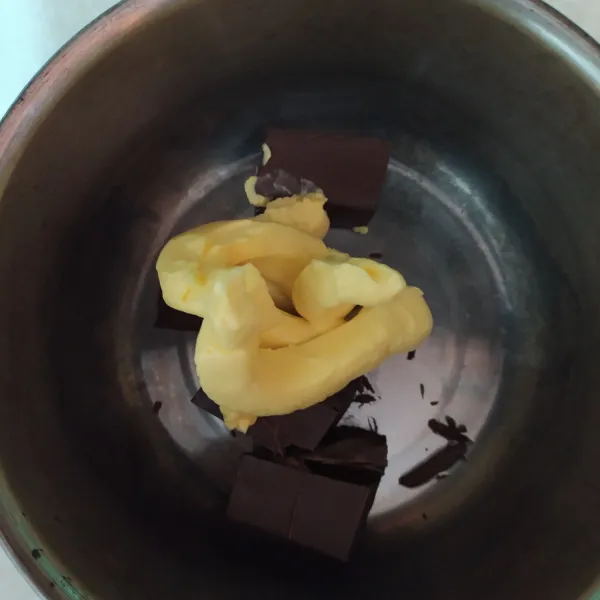 Sambil menunggu pisang beku, siapkan panci untuk membuat saus cokelat. Masukkan dark cooking chocolate (DCC) dan margarin.