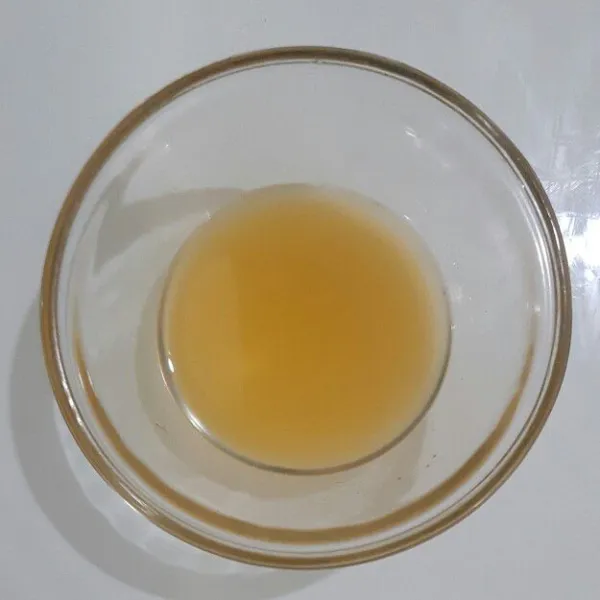 Peras lemon cui tuang airnya dalam wadah bersih.
