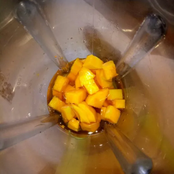 Kupas buah mangga, potong dadu lalu blender sebagian buah mangga bersama air gula yang sudah dimasak tadi sampai lembut.