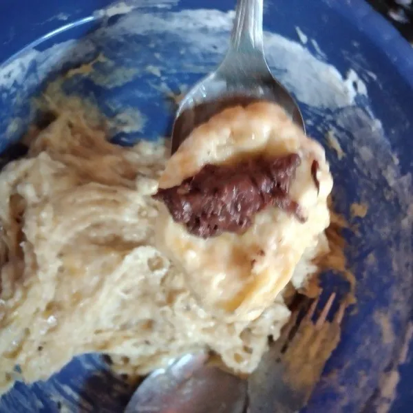 Jika sudah tercampur rata, ambil 1 sendok adonan kemudian beri lubang tengahnya. Tambahkan selai choconut, kemudian tutup kembali.