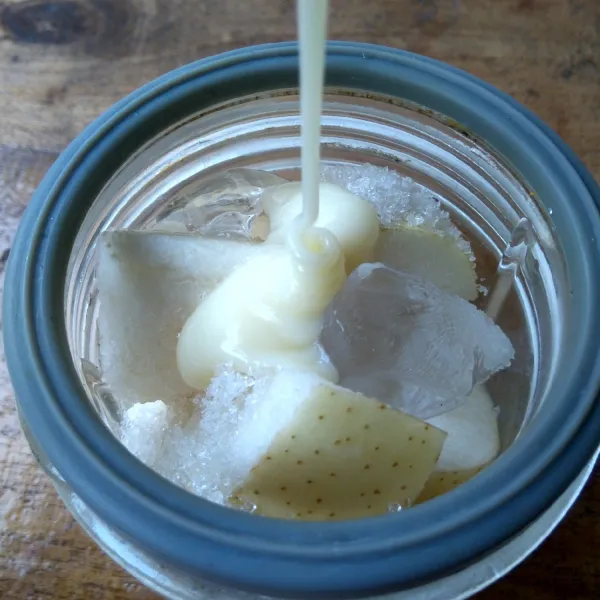 Masukkan potongan buah pir, es batu, gula pasir dan kental manis ke dalam blender. Tambahkan 100 ml air.