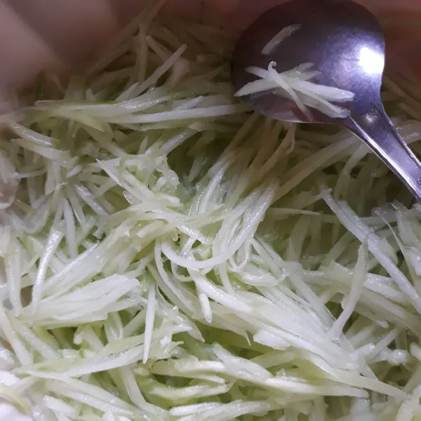 Kupas mentimun, belah dua dan buang isinya. Cuci bersih lalu serut mentimun.