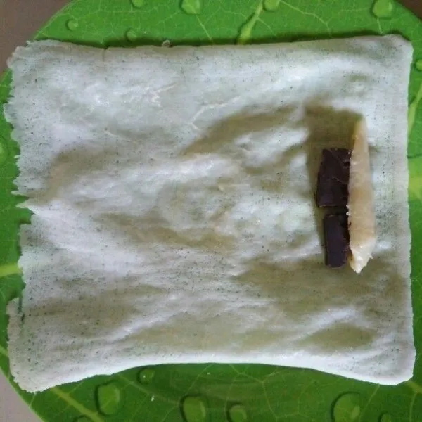 siapkan satu helai kulit lumpia lalu letakkam pisang yang telah di potong dan dark coklat di ujung kulit lumpia