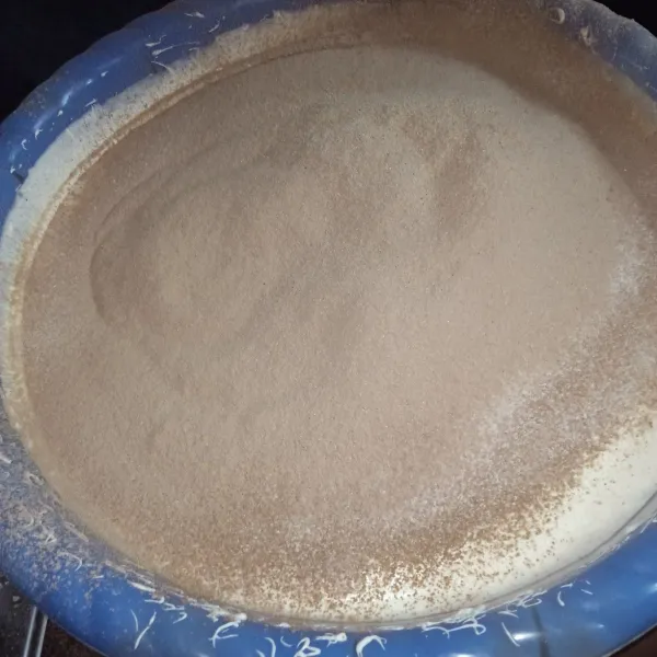Ayak tepung terigu, cocoa powder, vanili, dan milk powder, alu masukkan ke dalam adonan. Aduk hingga adonan tercampur rata.