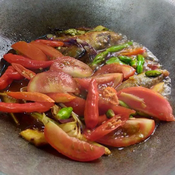 Masukkan tomat, cabai dan masak sampai tomat cabai layu tambah dengan air.