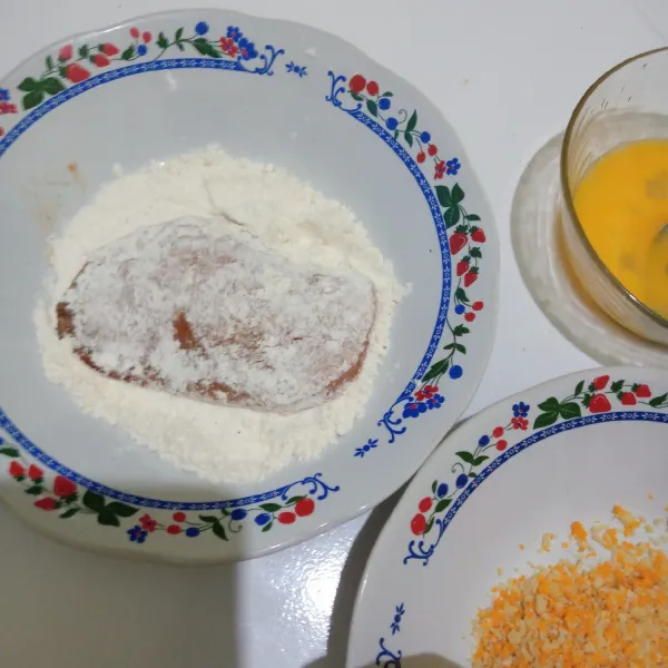Masukkan ayam yang telah di marinasi ke dalam tepung terigu, selanjutnya ke telur dan terakhir ke tepung panir.