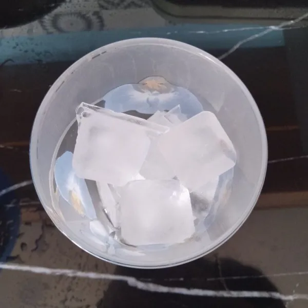 Masukkan es batu secukupnya ke dalam gelas.