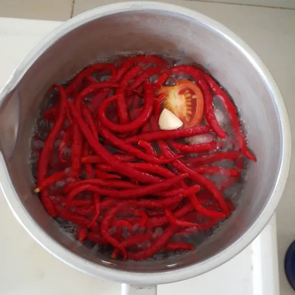 Lalu rebus cabai, tomat, bawang putih dan 1 bawang merah, sisakan 1 bawang merah yang diiris untuk menggoreng sambal.