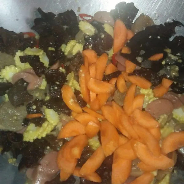 Tambahkan wortel dan jamur kuping. Masak hingga sedikit layu.