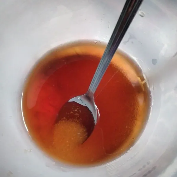 Masukkan takar 100 ml air teh kedalam gelas lain, beri 2 sdm gula pasir, aduk hingga gula larut