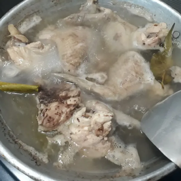 Rebus ayam dengan 2 lembar daun salam selama 10 menit, lalu tiriskan dan buang airnya. Sisihkan.
